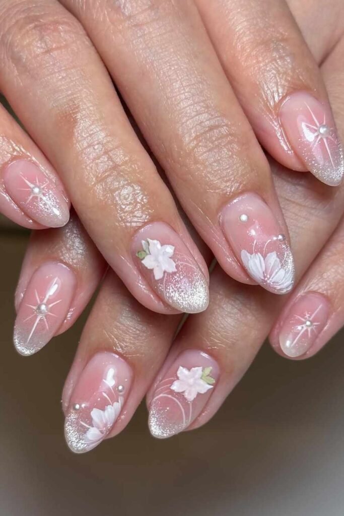 Shimmery cat eye effect in blush pink with floral details, dreamy pink nails for wedding guests.