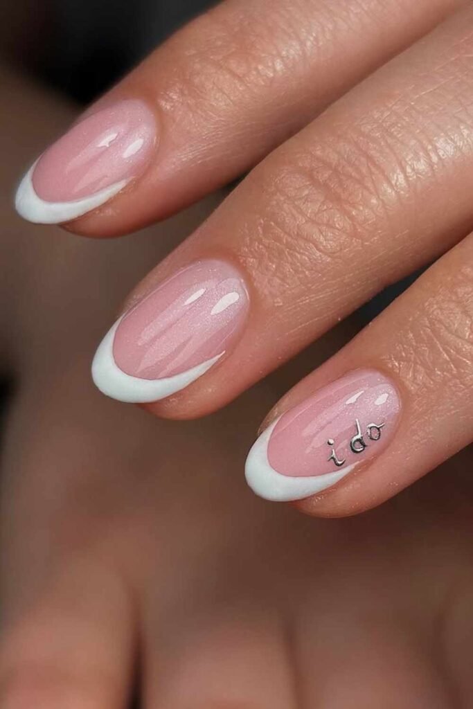 Minimal French tip bridal nails featuring dainty lettering that reads "I Do" in soft silver.