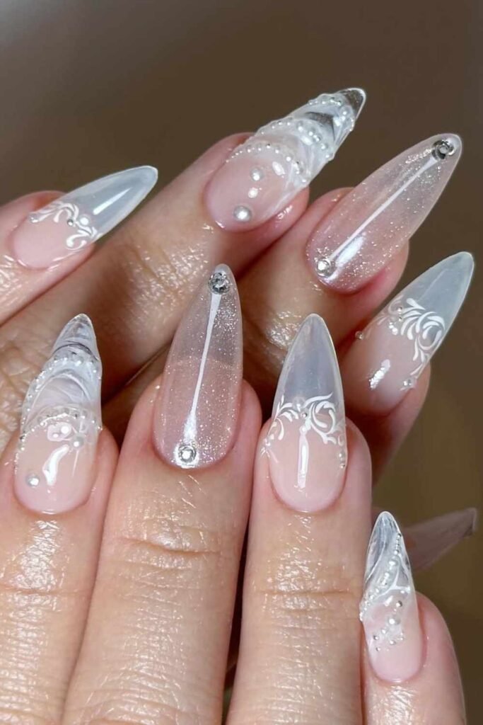 White lace pattern over a sheer nude base with pearl detailing; classic bridal nails with vintage charm.