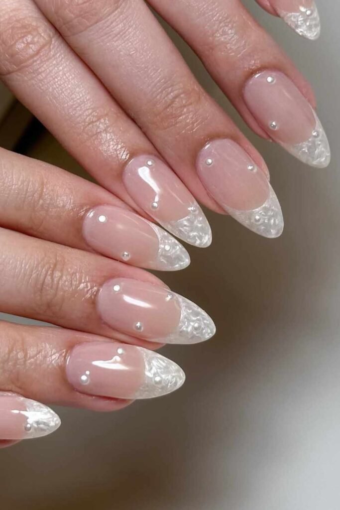 Glossy white mani with pearl accents on each fingertip, creating a soft and luxurious finish.