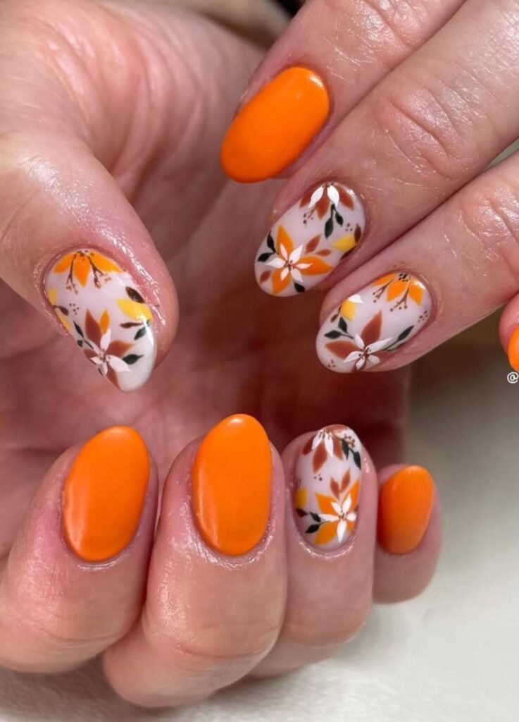 Bright autumn orange nails with delicate fall floral art