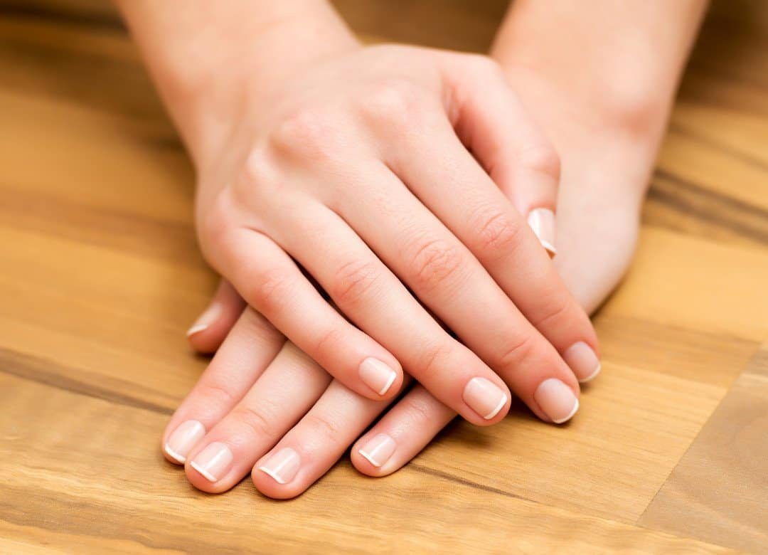 Beginner nail care aesthetic with clean girl vibes, featuring short natural nails with a glossy nude polish, hydrated cuticles, and minimal nail care tools for a simple at-home routine.