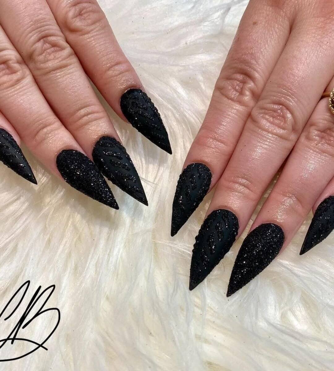 black nails with designs featuring A cosy twist that combines sweater-knit texture with a sprinkle of glossy texture