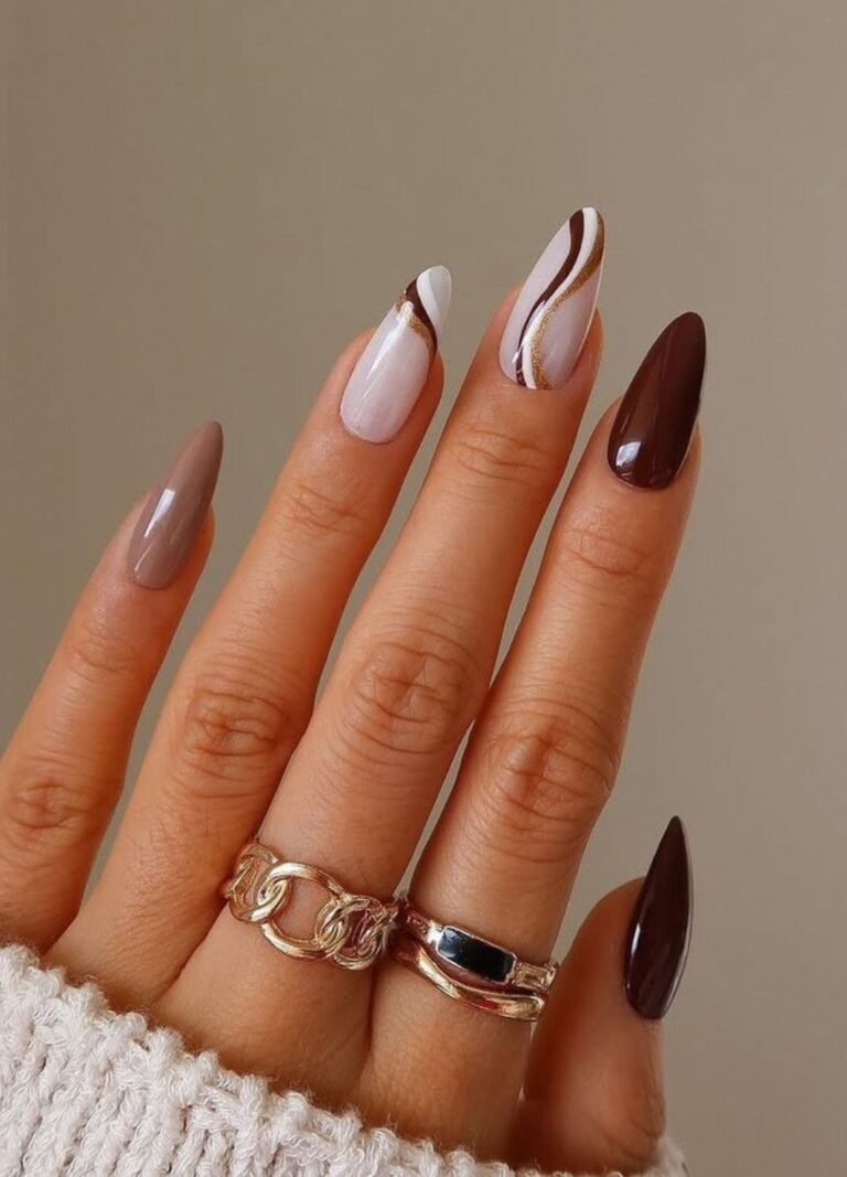 A lady's fingers showing Swirly nail art in deep, glossy brown, white and gold tones adds a retro yet modern vibe