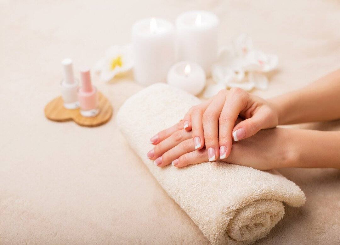 Essential nail care tips for beginners with clean, natural nails resting on a towel during an at-home nail care routine.