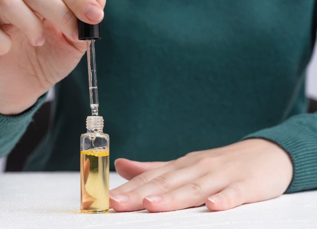 Natural nails looking long, strong, and healthy with cuticle oil and nail care tools beside them — showing how to grow nails faster and keep them from breaking at home.