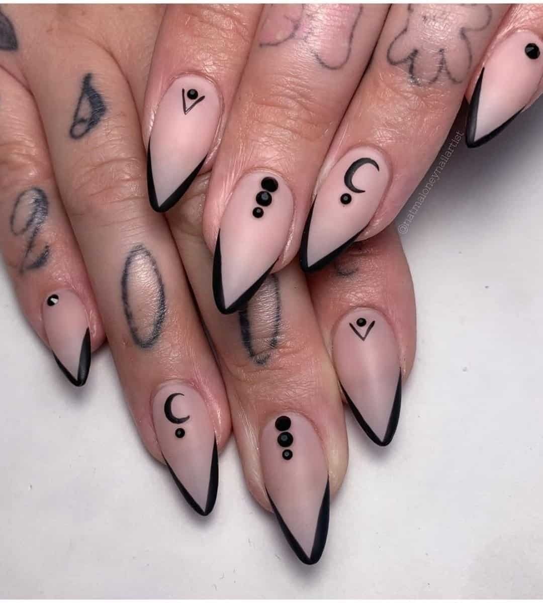 sleek black designs layered over nude nails