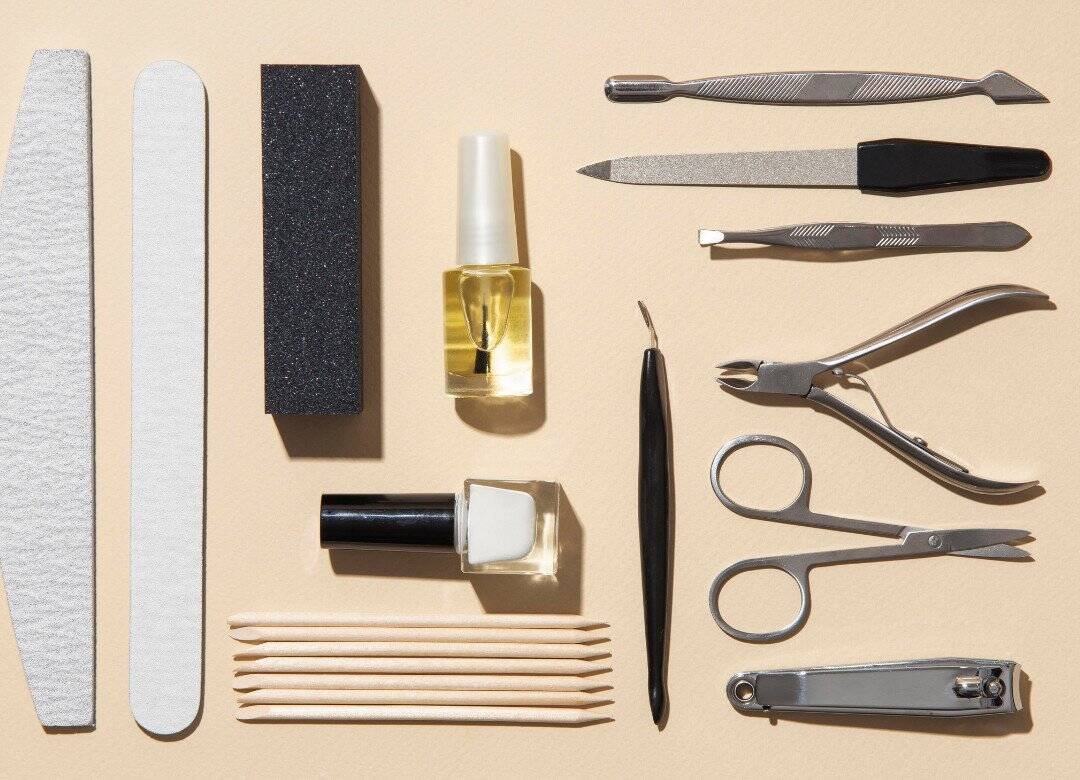 Must-have nail care tools and beginner nail care kit with nail clipper, file, buffer, and cuticle oil for a natural nail care routine at home.