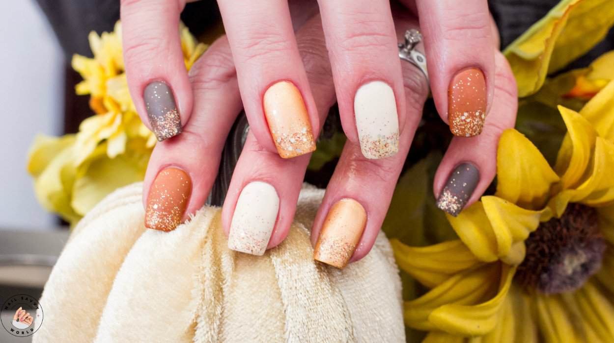 Nail care routine for fall with glossy burgundy autumn nails and minimalist fall nail design styled with cozy sweater and pumpkin spice latte.