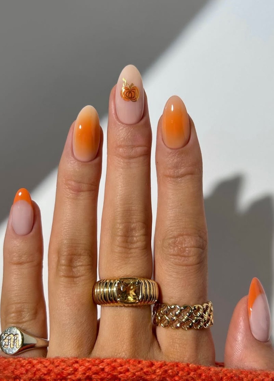 image of 5 fingers with golden rings and nails featuring Pumpkin orange blends seamlessly into ombre fades, while French tips add a classy, timeless finish. It’s the perfect choice if you want festive nails without going full-on Halloween.