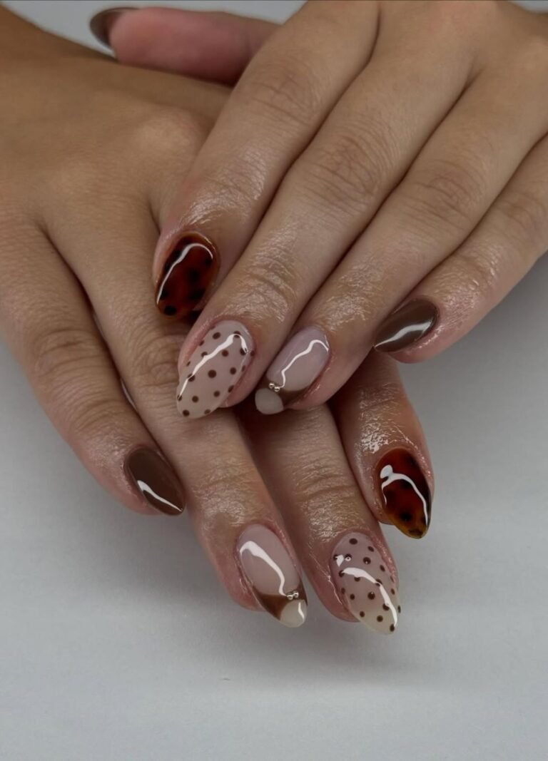 A woman's nails featuring A mix of timeless brown polka dots with chic tortoise shell accents makes this set feel quirky yet fashionable