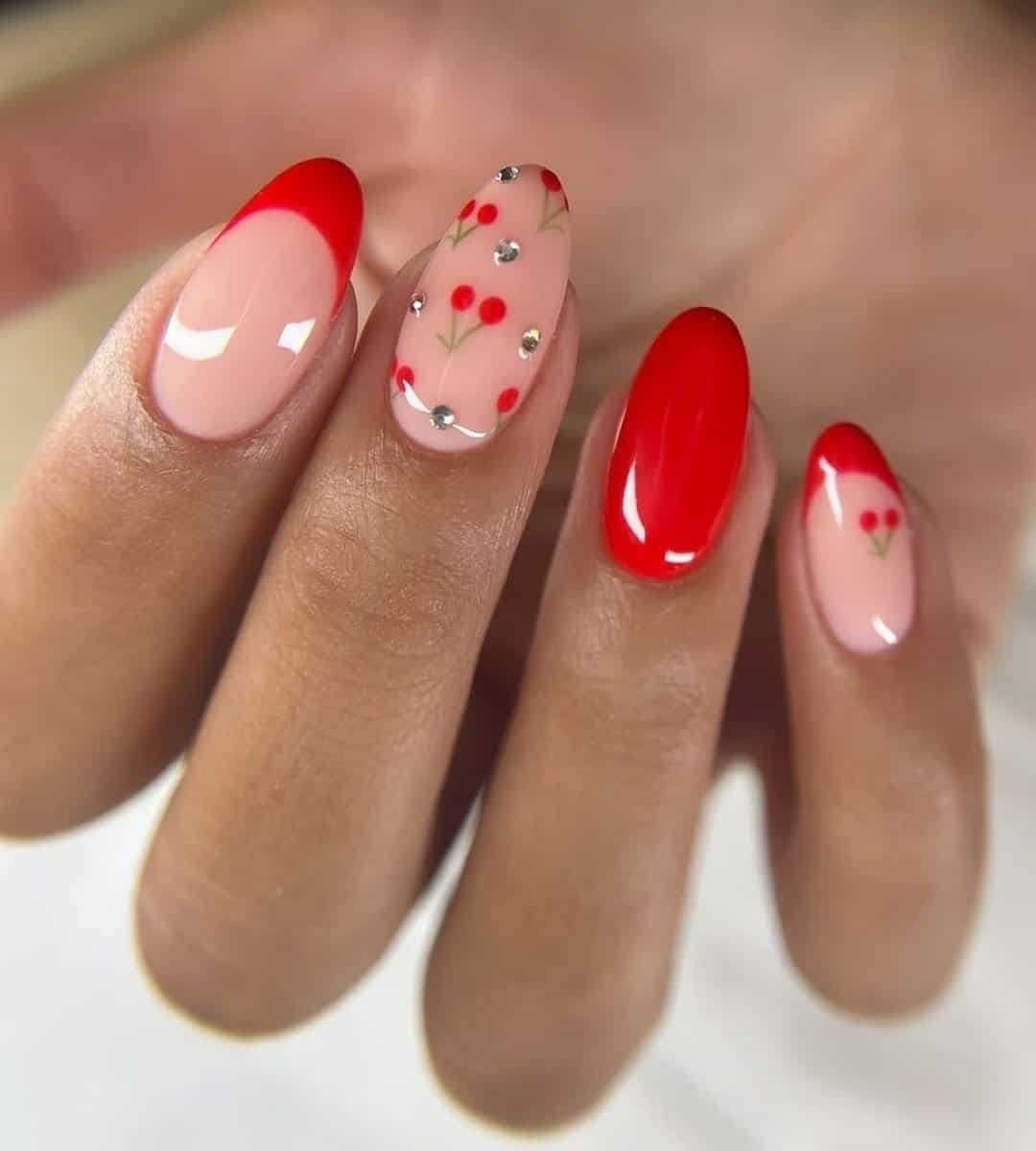 These cherry red nails mix cute cherry details with pearl embellishments and red French tips all in one set